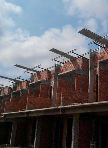 Partially constructed residential buildings with TH Clip Lock 710 (PPGI) roofing system in Mount Austin, Johor Bahru, under a partly cloudy sky.